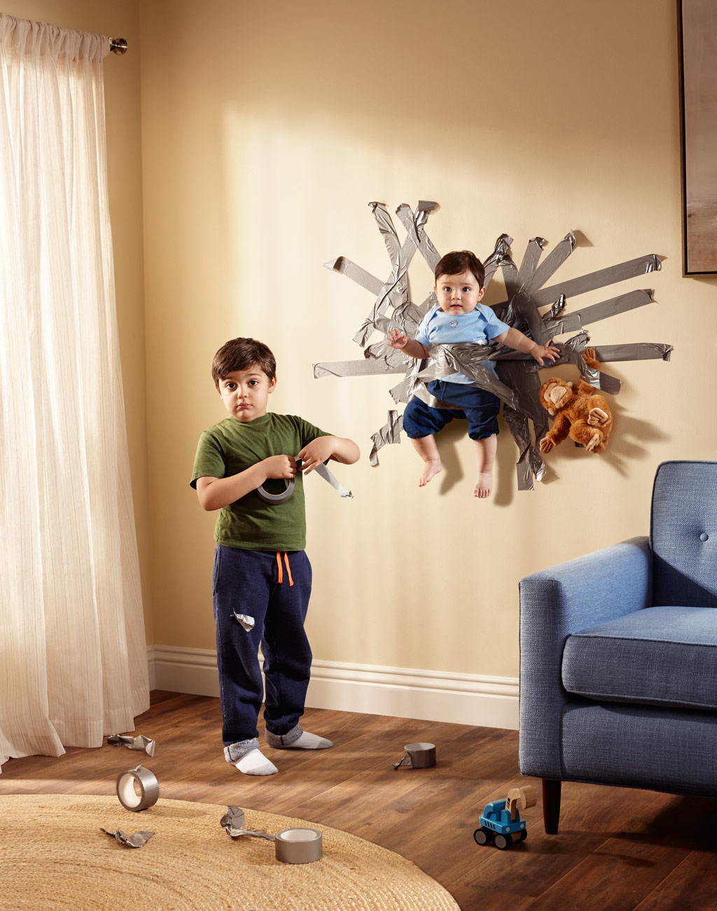 Boy taping smaller child to wall with duct tape | Conceptual portraits by Saverio Truglia