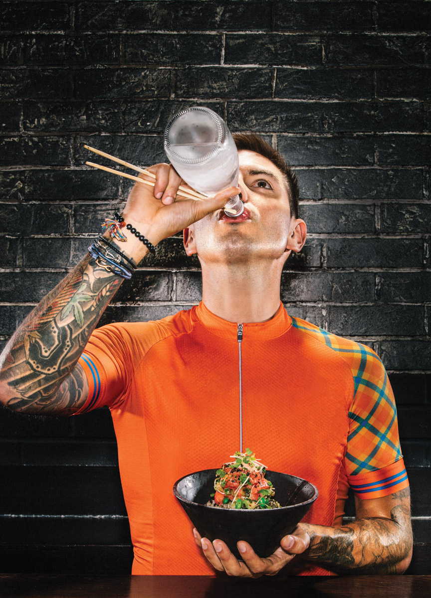 Man drinking water from glass bottle in cycling jersey | conceptual portrait by Saverio Truglia