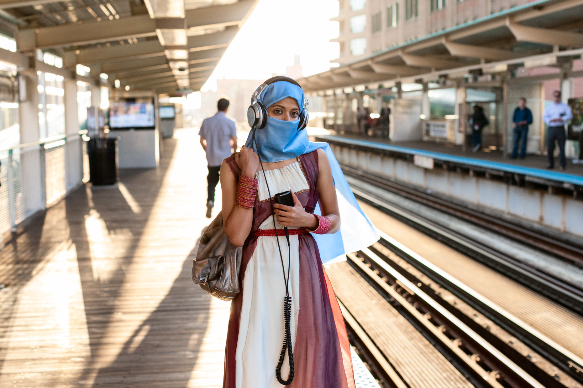 Woman in headscarf on train platform | Saverio Truglia