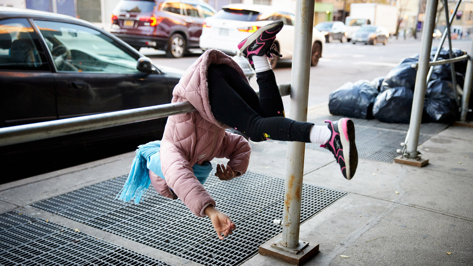 Child swinging on scaffolding in the city | Childrens photography by Saverio Truglia