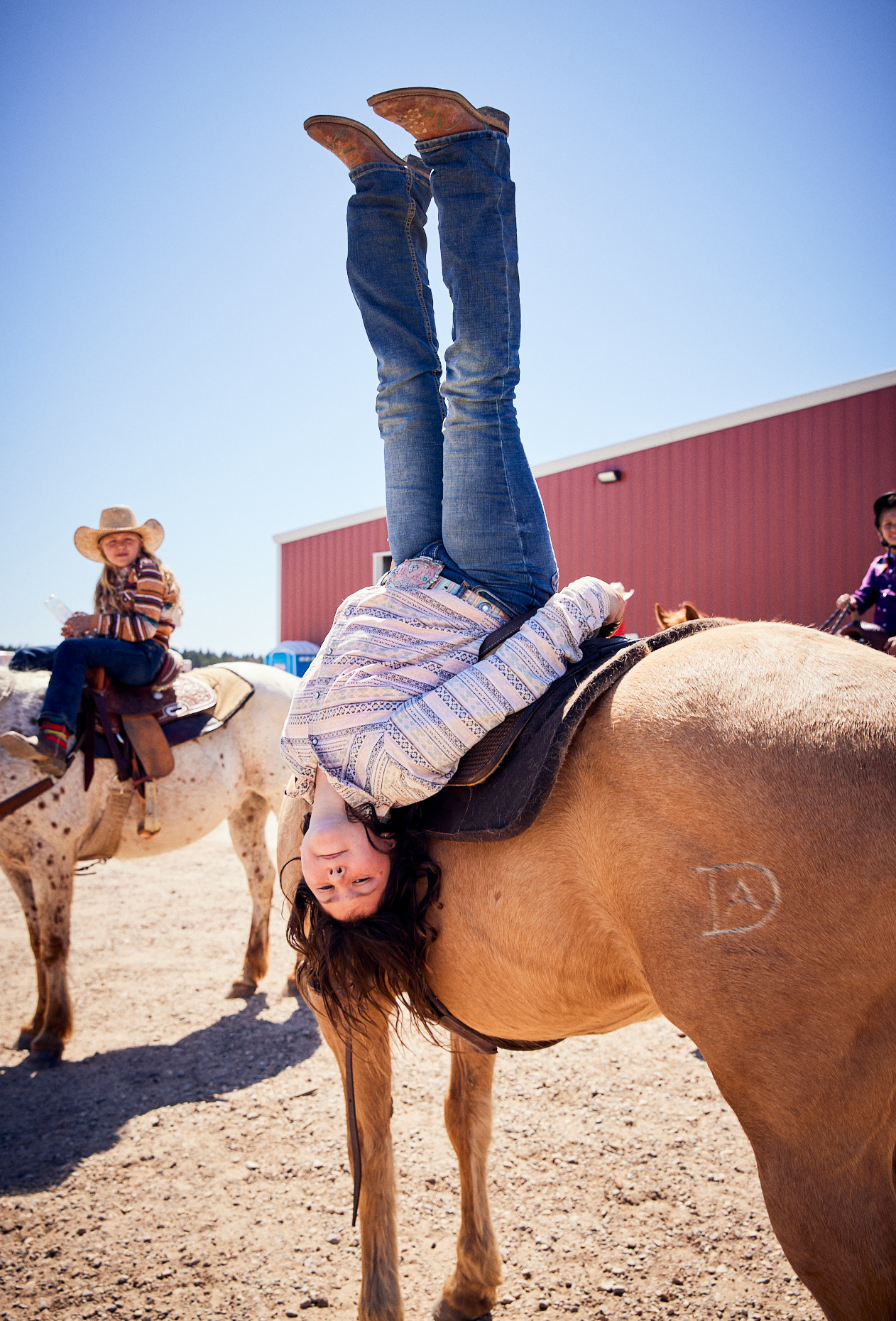 Girl swinging upside down on her horse | Childrens photography by Saverio Truglia