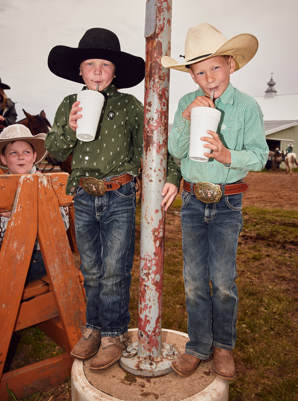 Boys at rodeo sipping soda from foam cups | Childrens photography by Saverio Truglia