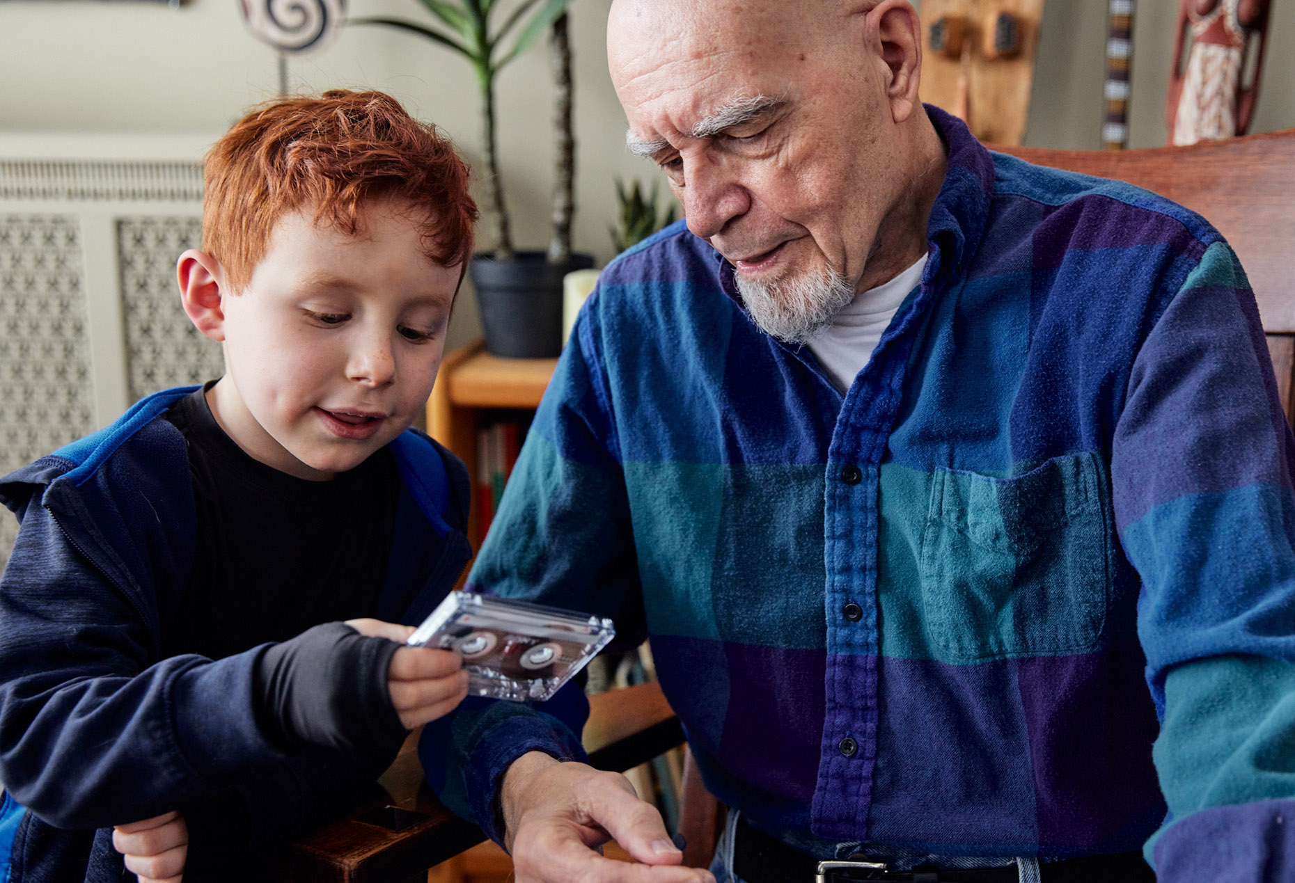 Boy showing a older person casette tape | Childrens photography by Saverio Truglia
