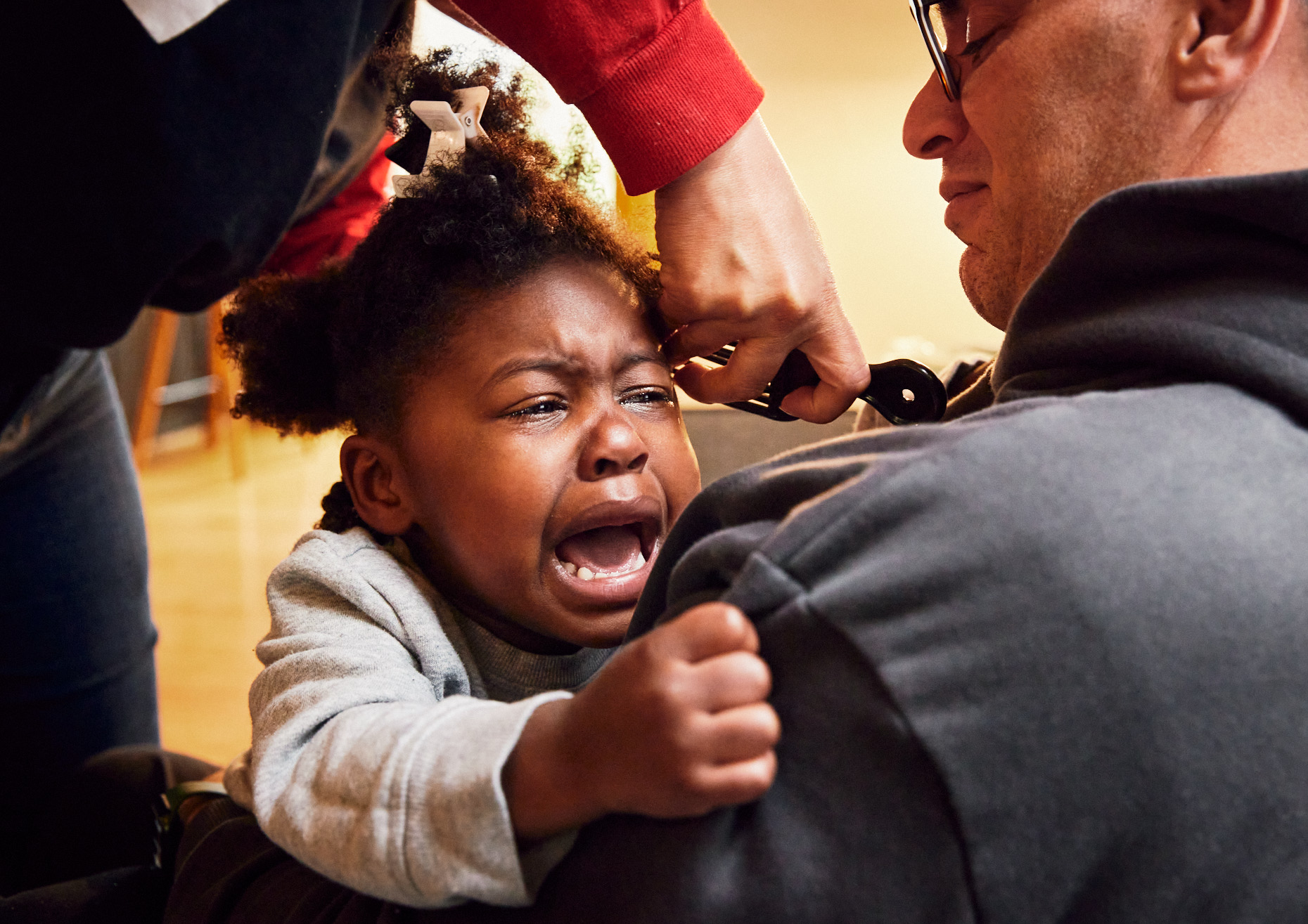 Toddler screaming while parents do her natural hair | Kids Photography by Saverio Truglia