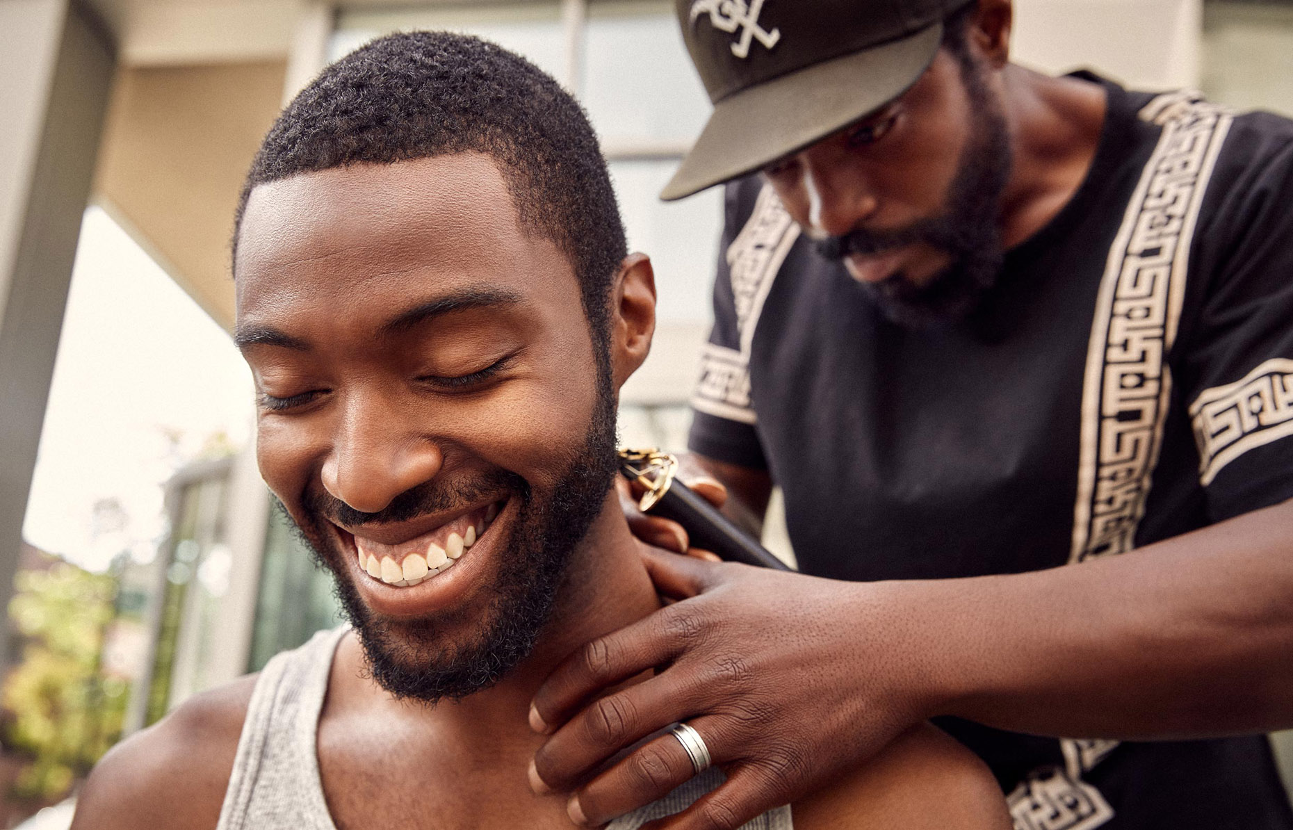 Smiling Black man enjoying a haircut | lifestyle photography by Saverio Truglia