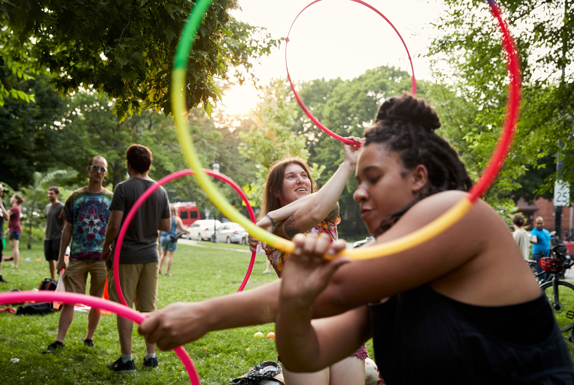 Jugglers twirling hoolahoops in the park | lifestyle photography by Saverio Truglia