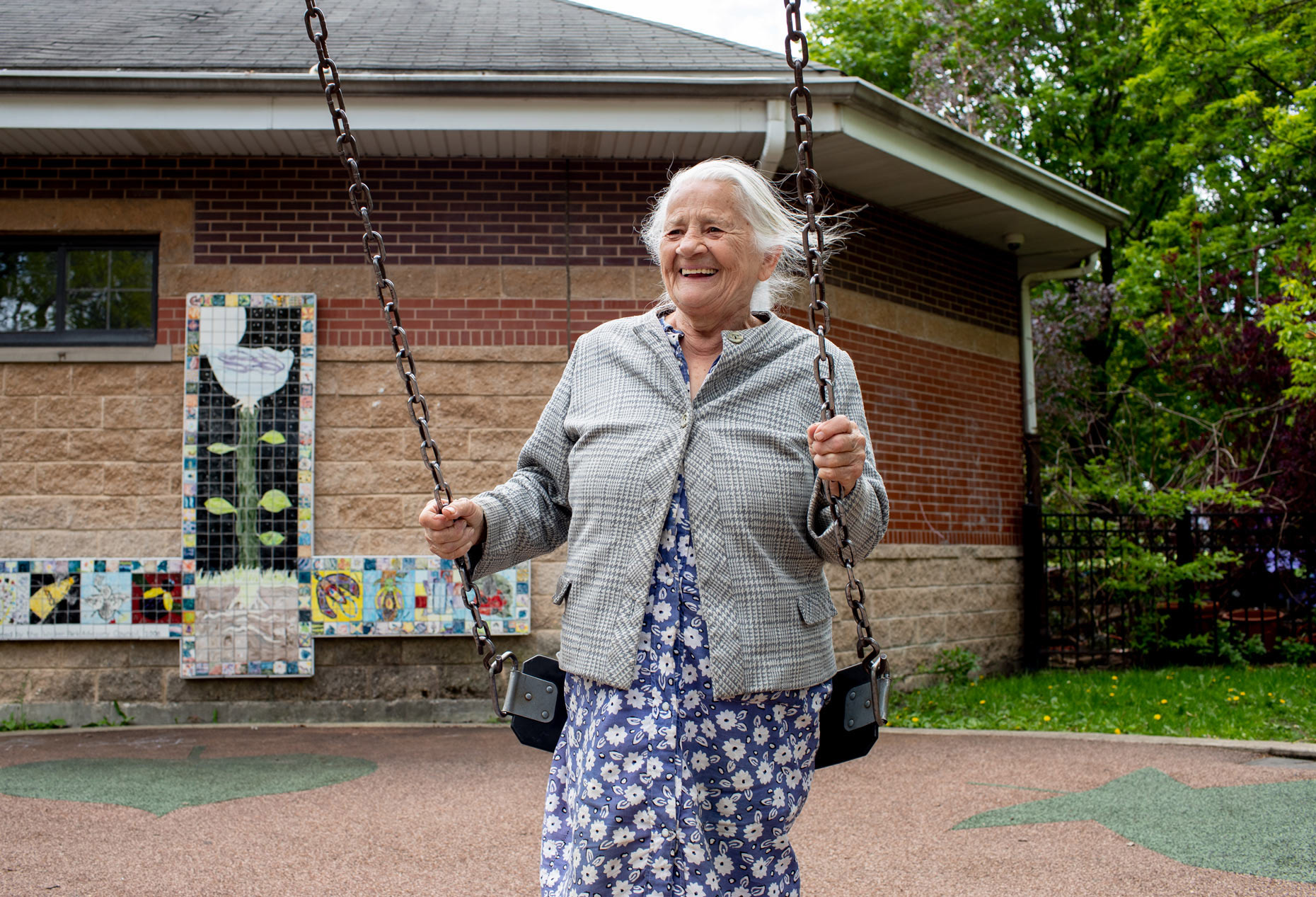 Older European woman swinging at a park | lifestyle photography by Saverio Truglia