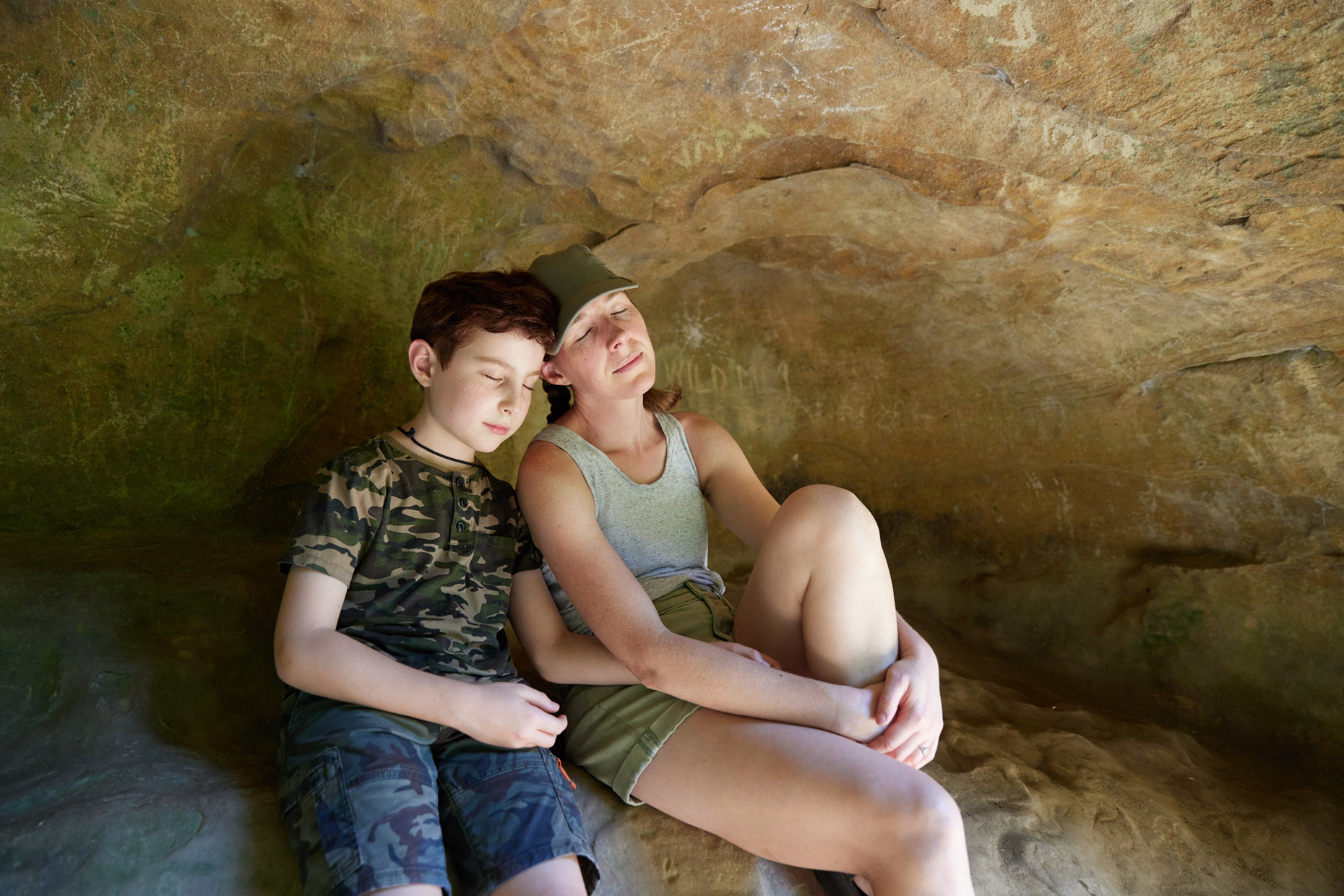 Mother and son meditating in a sandstone cave | lifestyle photography by Saverio Truglia
