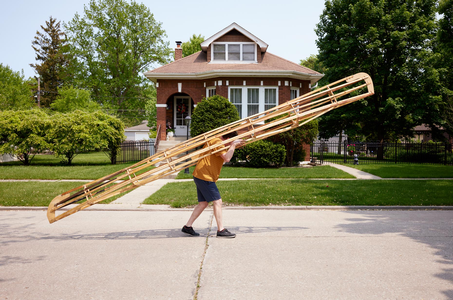 man walking in the street with canoe on his back | Quirky portraits by Saverio Truglia